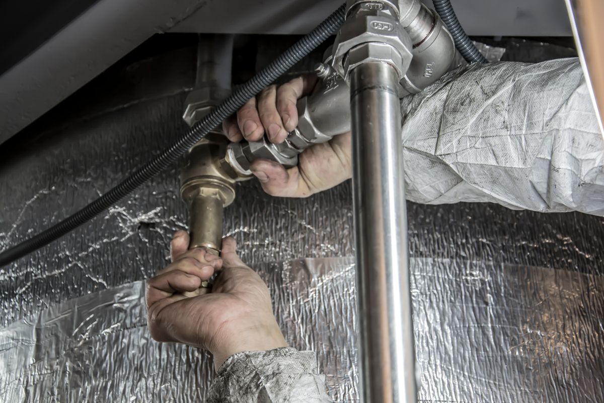 Teknisyen doğalgaz boru bağlantısını monte ederken